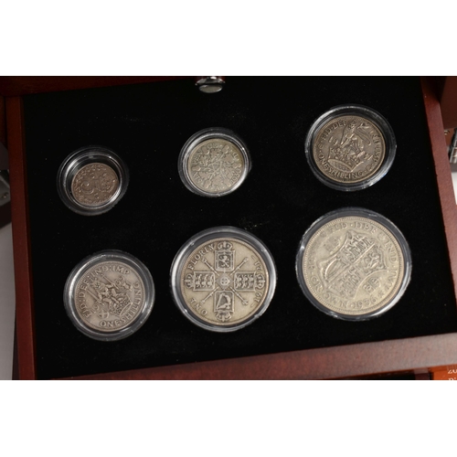 229 - A GLAZED DISPLAY BOX THREE DECADES of GEORGE V STAMP AND COIN SET, to include four trays of silver c... 