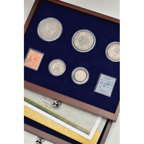 229 - A GLAZED DISPLAY BOX THREE DECADES of GEORGE V STAMP AND COIN SET, to include four trays of silver c... 