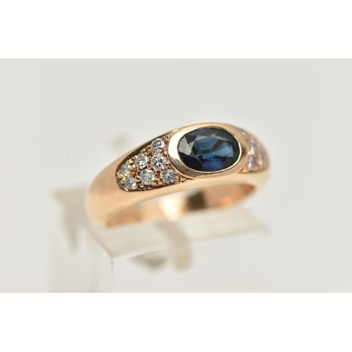 48 - A YELLOW METAL SAPPHIRE AND DIAMOND RING, designed with a central oval cut deep blue sapphire, flank... 