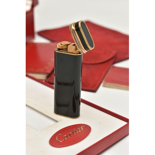 144 - A 'MUST DE CARTIER' LIGHTER, gilt lighter with black lacquer and trinity band, serial 28008T, with a... 