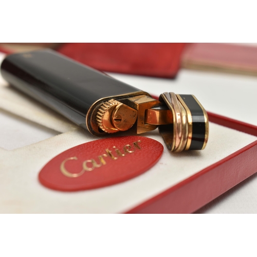 144 - A 'MUST DE CARTIER' LIGHTER, gilt lighter with black lacquer and trinity band, serial 28008T, with a... 