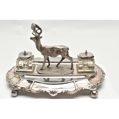 201 - A LATE VICTORIAN SILVER PLATE DESK STAND, featuring a stag to the centre, with two glass ink jars fi... 