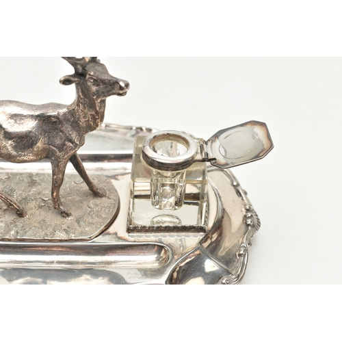 201 - A LATE VICTORIAN SILVER PLATE DESK STAND, featuring a stag to the centre, with two glass ink jars fi... 