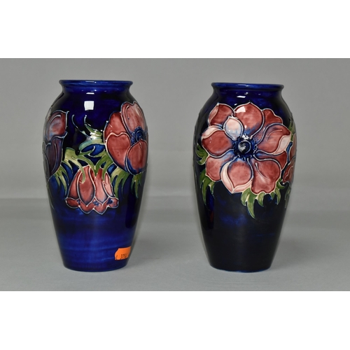 369 - TWO MOORCROFT VASES, purple and mauve anemone design on a dark blue ground, height 19cm, blue painte... 