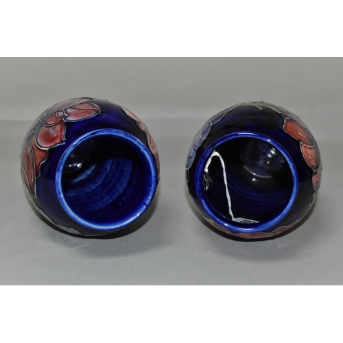 369 - TWO MOORCROFT VASES, purple and mauve anemone design on a dark blue ground, height 19cm, blue painte... 