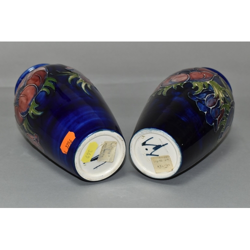 369 - TWO MOORCROFT VASES, purple and mauve anemone design on a dark blue ground, height 19cm, blue painte... 