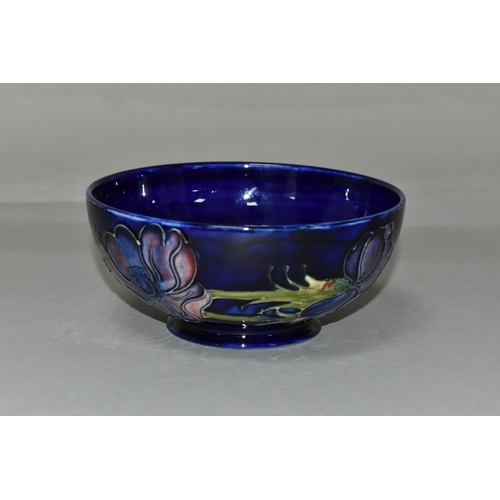 386 - A MOORCROFT POTTERY 'ANEMONE' BOWL, tube lined with red and purple anemones on a dark blue ground, p... 