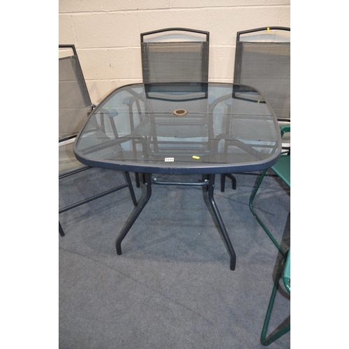 1115 - A HOMEBASE GLASS TOPPED GARDEN TABLE with three matching chairs and two other folding chairs