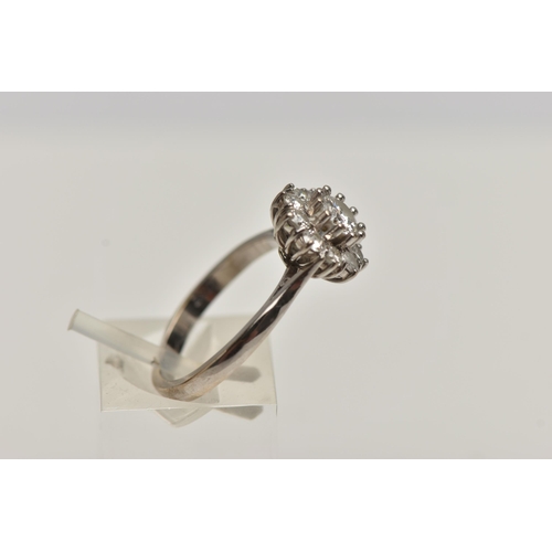 2 - A MODERN DIAMOND CLUSTER RING, a principle round brilliant cut diamond prong set in white metal, wit... 