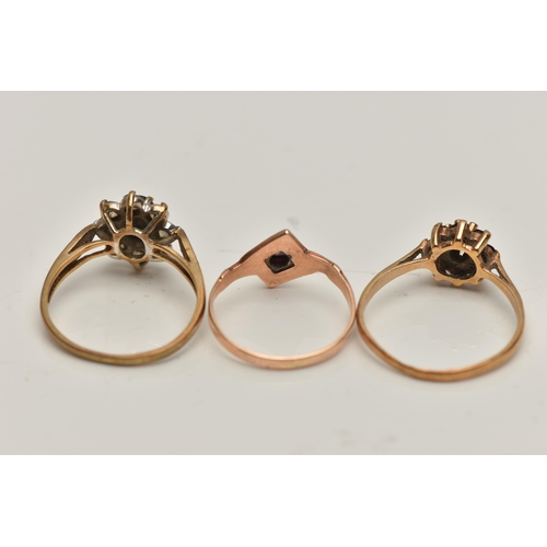 23 - THREE YELLOW METAL RINGS, the first a garnet cluster ring, stamped gold, ring size O, a sapphire and... 