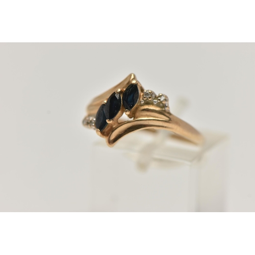 65 - A YELLOW METAL GEM SET RING, designed as a row of three marquise cut deep blue sapphires asymetrical... 