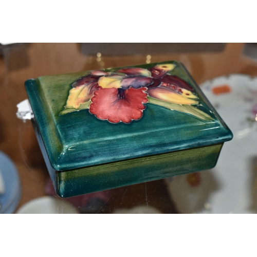 363 - A MOORCROFT POTTERY RECTANGULAR TRINKET BOX AND COVER, green / blue ground, decorated with an orchid... 