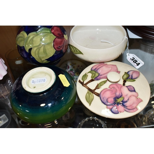 384 - THREE PIECES OF MOORCROFT POTTERY, comprising a Magnolia pattern covered pot, a Clematis vase height... 