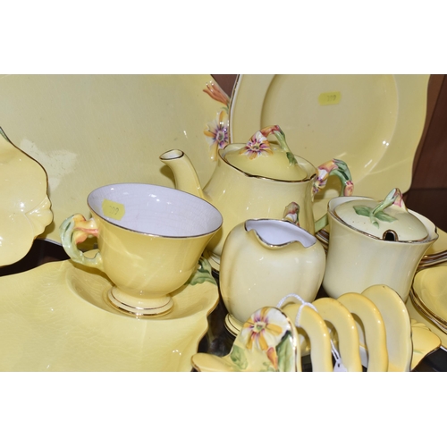 399 - A LARGE QUANTITY OF ROYAL WINTON YELLOW  'PETUNIA' PATTERN TABLEWARE, comprising a square cake plate... 