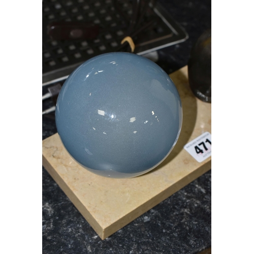 471 - A FRENCH ART DECO TABLE LAMP, featuring a seated cat figure and a blue glass globe shade on a stone ... 