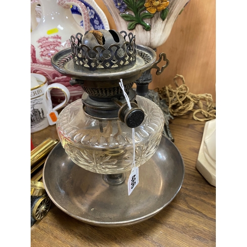 466 - AN OIL LAMP, square brass base with a ceramic reservoir decorated with applied flowers, white glass ... 