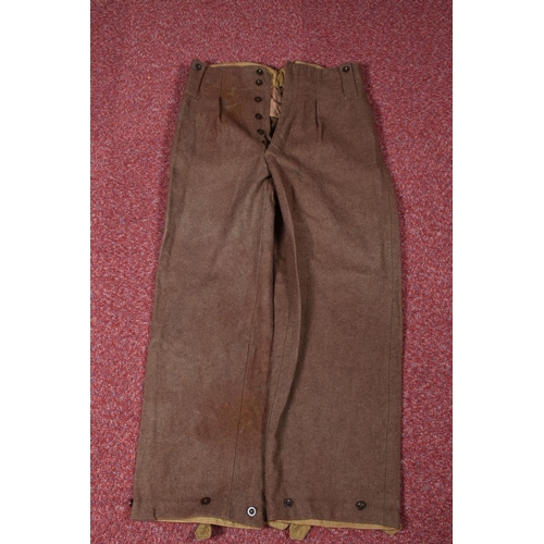 323 - EIGHT ITEMS OF MILITARY CLOTHING, to include WWII dated trousers, this lot includes a pair of 1943 s... 