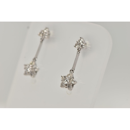 121 - A PAIR OF 18CT WHITE GOLD DIAMOND DROP EARRINGS, each earring designed with a diamond set flower dro... 