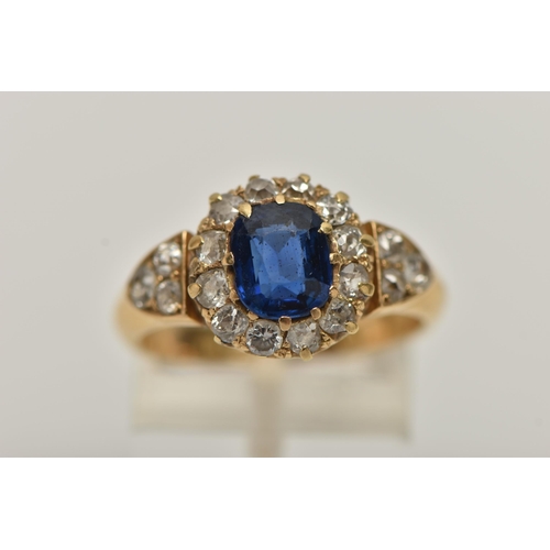 174 - A YELLOW METAL SAPPHIRE AND DIAMOND CLUSTER RING, centring on a cushion cut blue sapphire, measuring... 