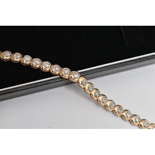 177 - A 9CT GOLD DIAMOND LINE BRACELET, designed as a series of circular links each set with a small round... 