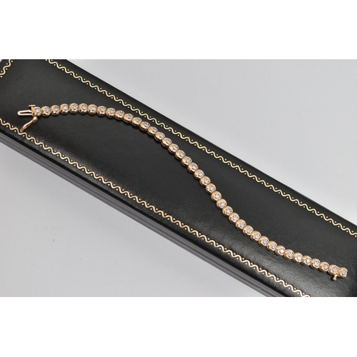 177 - A 9CT GOLD DIAMOND LINE BRACELET, designed as a series of circular links each set with a small round... 