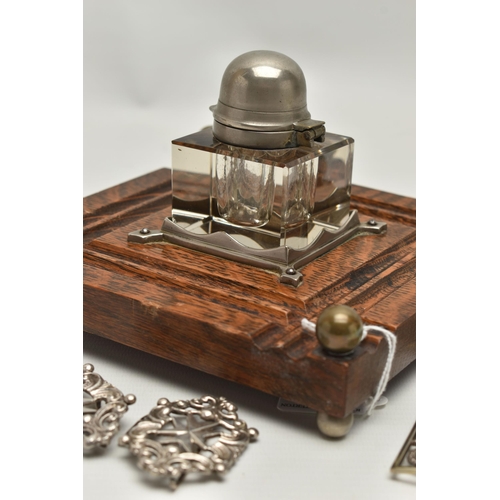 241 - AN INKWELL AND TWO NURSES BELT BUCKLES, a glass and white metal inkwell together with an oak, white ... 