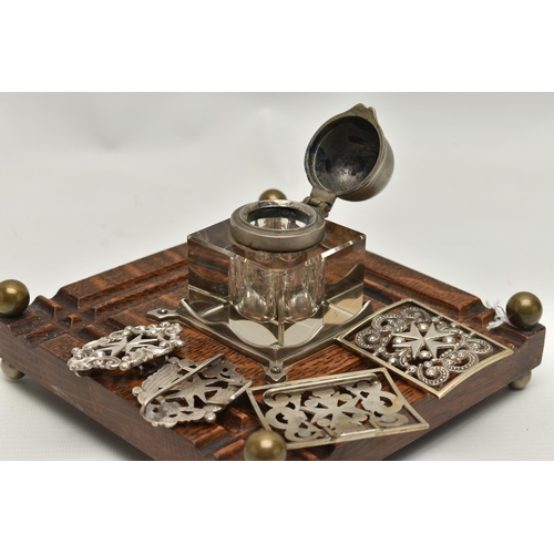 241 - AN INKWELL AND TWO NURSES BELT BUCKLES, a glass and white metal inkwell together with an oak, white ... 