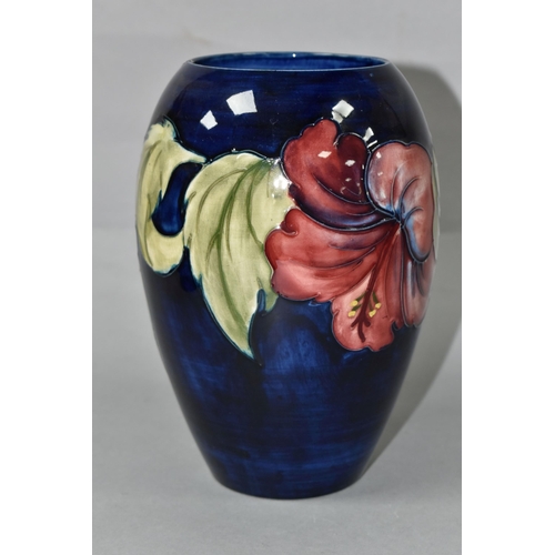 453 - A MOORCROFT POTTERY VASE, of baluster form with a mauve and yellow Hibiscus pattern on a blue ground... 