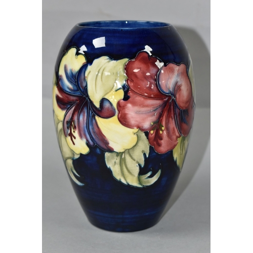 453 - A MOORCROFT POTTERY VASE, of baluster form with a mauve and yellow Hibiscus pattern on a blue ground... 