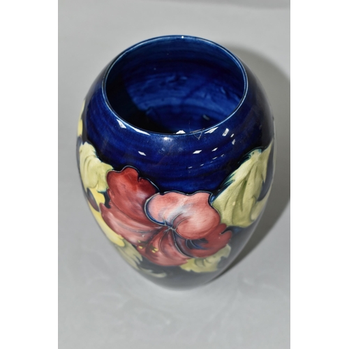 453 - A MOORCROFT POTTERY VASE, of baluster form with a mauve and yellow Hibiscus pattern on a blue ground... 