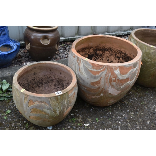 1011 - THREE LARGE TERRACOTTA GARDEN POTS, diameter 50cm x height 40cm, along with a pair of smaller terrac... 