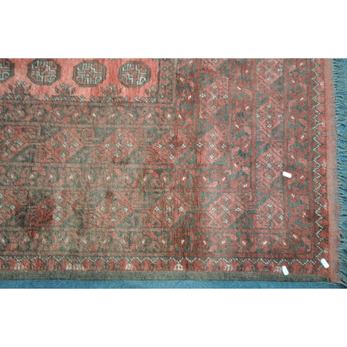 1214 - A LARGE WOOLLEN TEKKE RUG, with a central red field and multi strap boarder, 340cm x 255cm (conditio... 