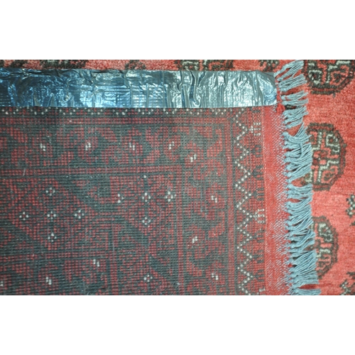 1214 - A LARGE WOOLLEN TEKKE RUG, with a central red field and multi strap boarder, 340cm x 255cm (conditio... 