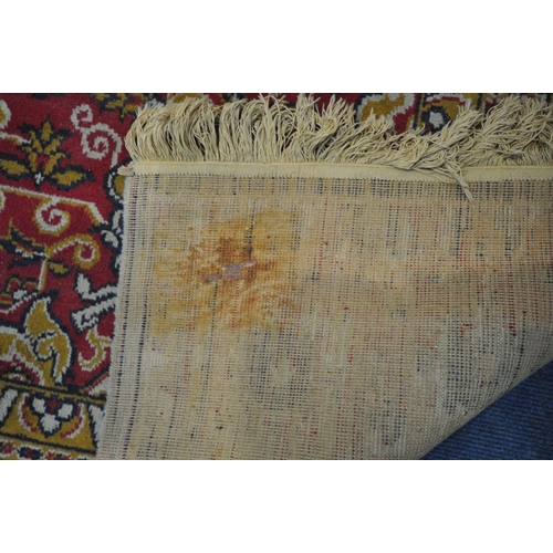 1227 - A LARGE WOOLLEN HEREKE TYPE RUG, with a red and a cream field, 348cm x 251cm (condition report: - in... 