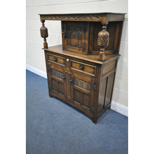 1235 - A REPRODUCTION CARVED OAK COURT CUPBOARD, with two drawers and three cupboards, width 110cm x depth ... 