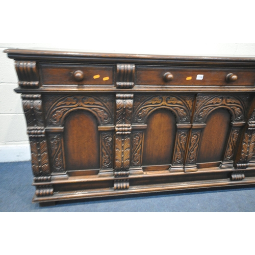 1236 - A REPRODUCTION CARVED OAK SIDEBOARD, with three drawers over four doors, width 180cm x depth 58cm x ... 