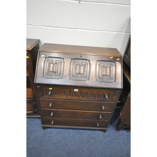 1280 - A 20TH CENTURY OAK LINENFOLD BUREAU, the fall front door enclosing a fitted interior, above four dra... 