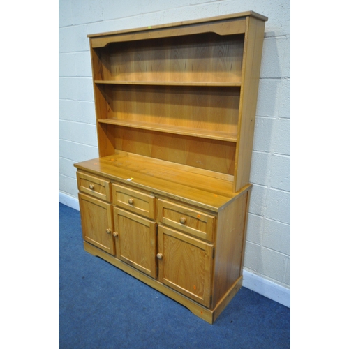 1315 - A MODERN PINE DRESSER, the top with two tier plate rack, the base with three drawers and cupboard do... 