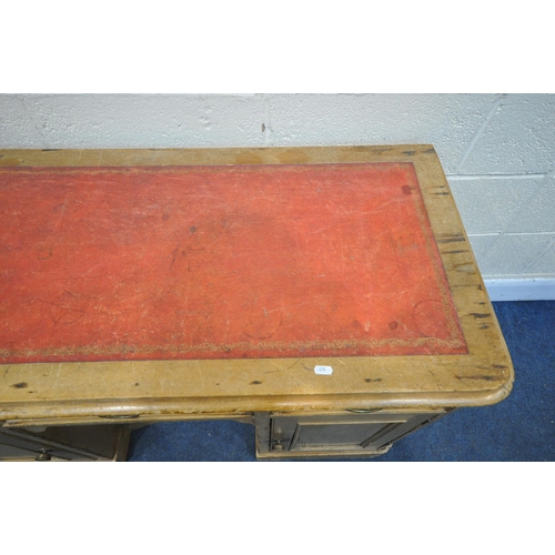 1320 - A VICTORIAN PINE KNEEHOLE DESK, with a red and tooled leather writing surface, three drawers, above ... 