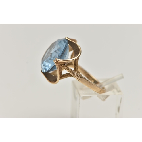 20 - A 9CT GOLD GEM SET DRESS RING, set with a circular cut light blue stone assessed as synthetic spinel... 