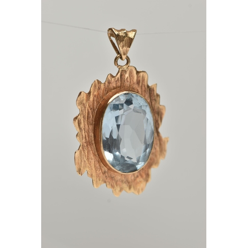 21 - A 9CT GOLD BLUE TOPAZ PENDANT, yellow textured gold mount set with an oval cut light blue topaz, hal... 