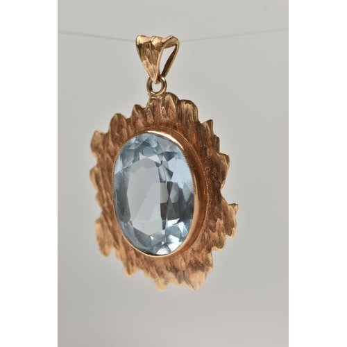 21 - A 9CT GOLD BLUE TOPAZ PENDANT, yellow textured gold mount set with an oval cut light blue topaz, hal... 