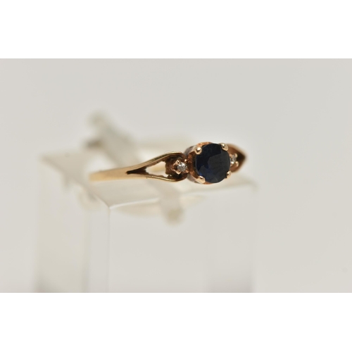 31 - A YELLOW METAL SAPPHIRE AND DIAMOND RING, centring on a circular cut deep blue sapphire, four claw s... 