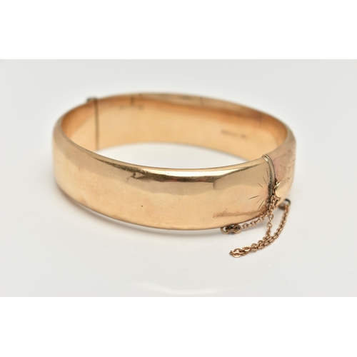 8 - A 9CT GOLD HINGED BANGLE, foliage pattern to one side, fitted with a push piece clasp with additiona... 