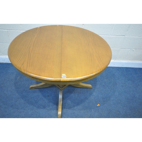 1234 - A MODERN OAK EXTENDING DINING TABLE, with a single fold out leaf, open length 145cm x diameter 107cm... 