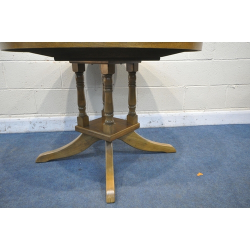 1234 - A MODERN OAK EXTENDING DINING TABLE, with a single fold out leaf, open length 145cm x diameter 107cm... 