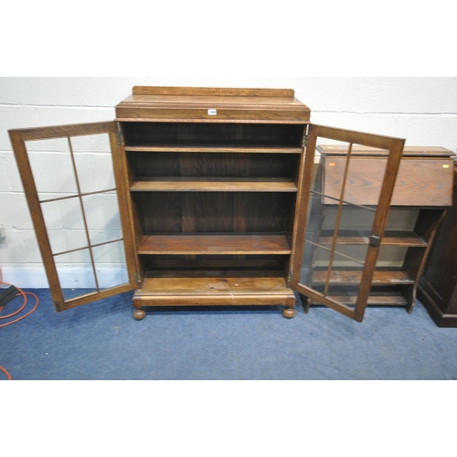 1264 - A 20TH CENTURY OAK GLAZED DOUBLE DOOR BOOKCASE, with a raised back and bun feet, width 85cm x depth ... 