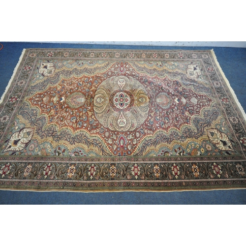 1274 - A KERMAN STYLE WOOLLEN RUG, with a central design within a red fields and multi strap border, 290cm ... 