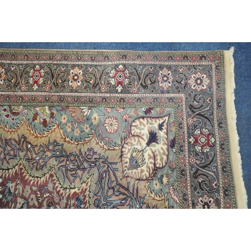 1274 - A KERMAN STYLE WOOLLEN RUG, with a central design within a red fields and multi strap border, 290cm ... 