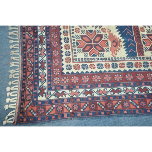1275 - A GEOMETRIC WOOLLEN RUG, with repeating pattern, on a cream field, and a multi strap border, 298cm x... 